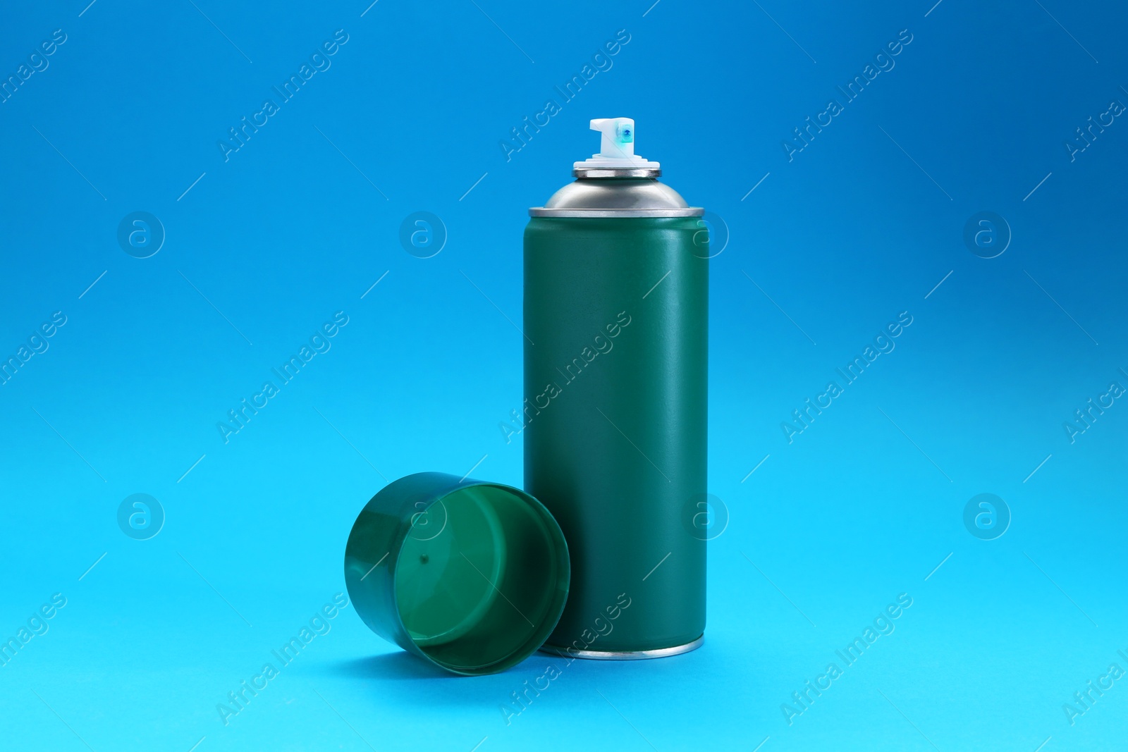 Photo of Green spray paint can on light blue background