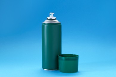 Photo of Green spray paint can on light blue background