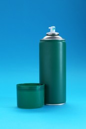 Photo of Green spray paint can on light blue background