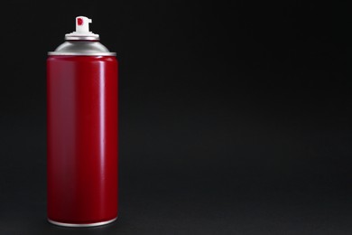 Photo of Red spray paint can on black background, space for text