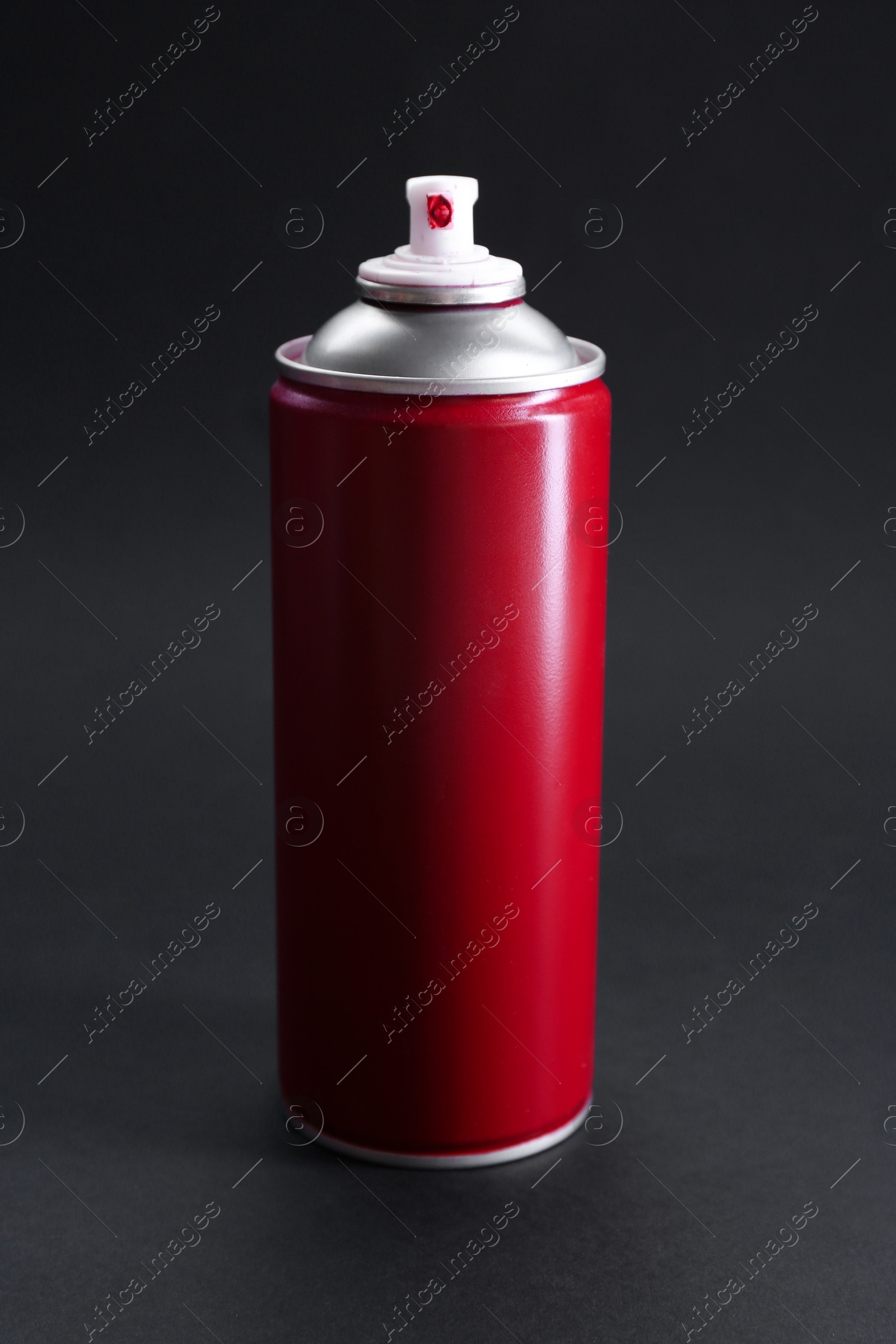 Photo of Red spray paint can on dark gray background