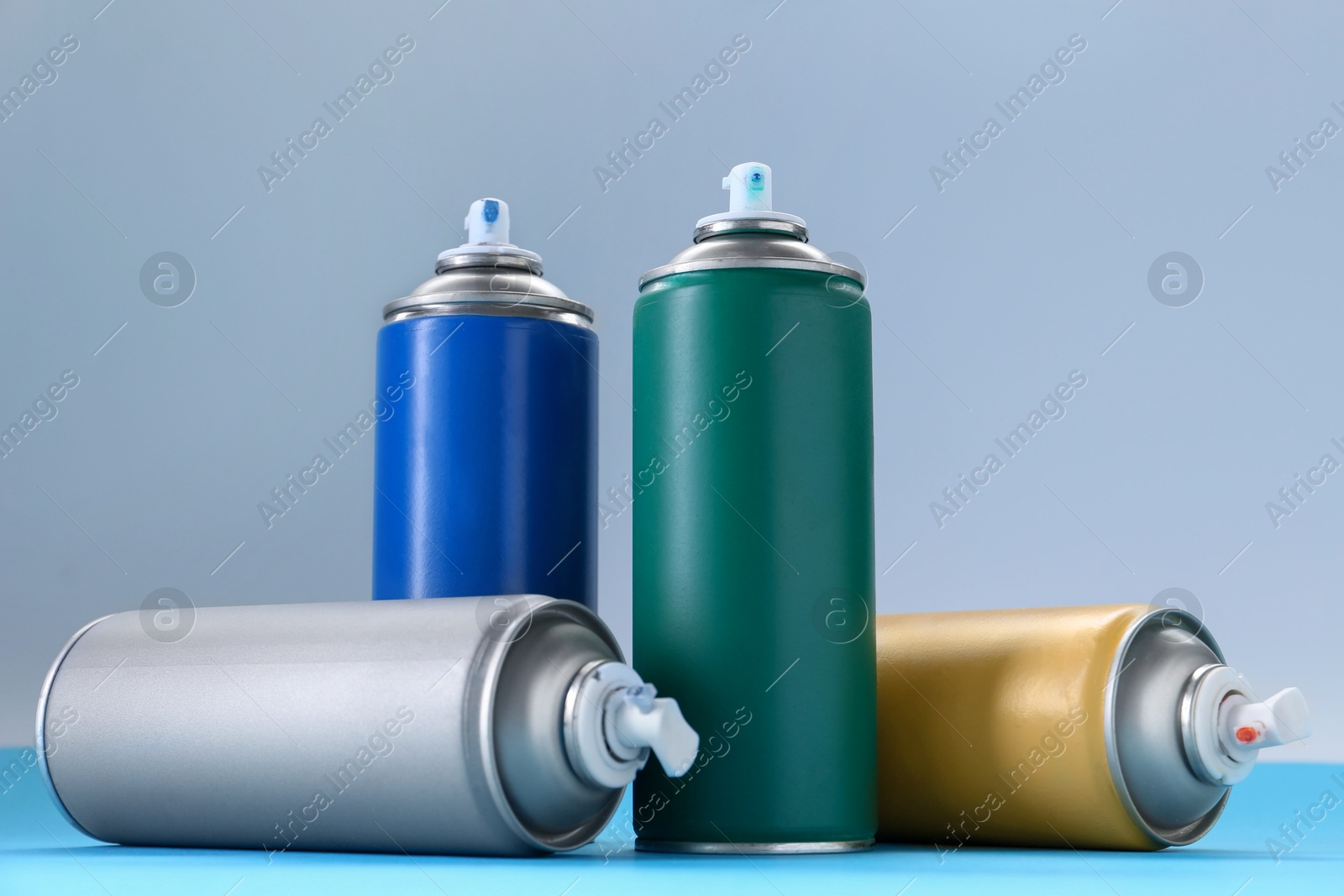 Photo of Many spray paint cans on color background