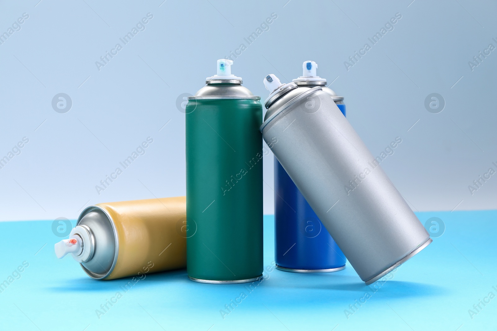 Photo of Many spray paint cans on color background