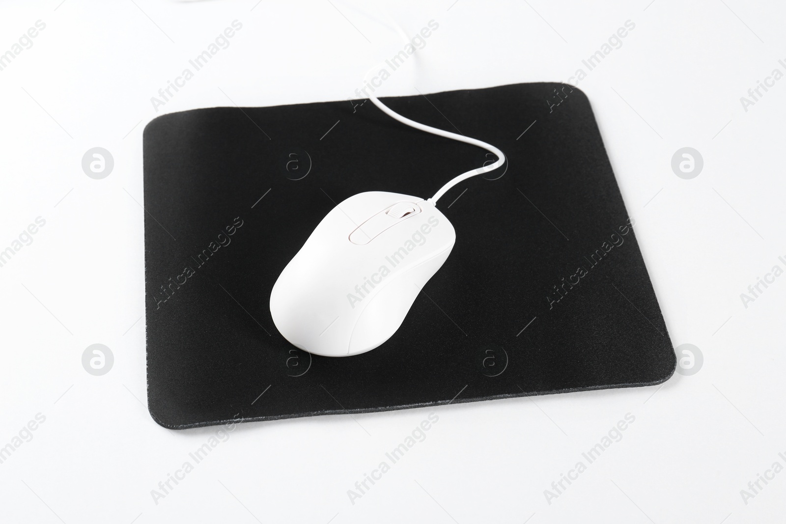 Photo of Wired mouse and mousepad on white background