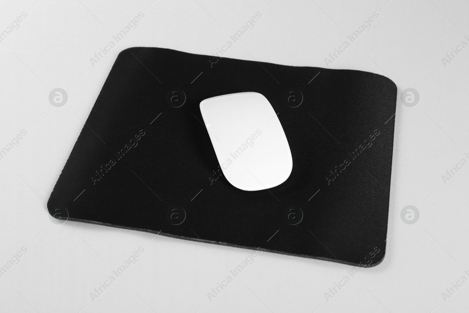 Photo of Wireless mouse and mousepad on white background