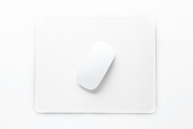 Photo of Wireless mouse and mousepad on white background, top view