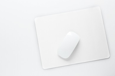 Wireless mouse and mousepad on white background, top view