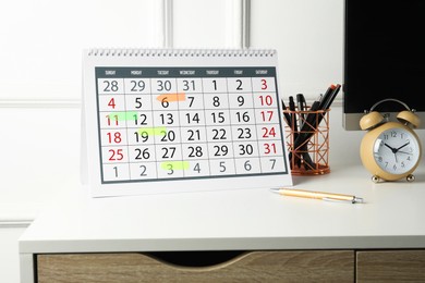 Timetable. Calendar with marked dates, alarm clock and stationery on white table indoors