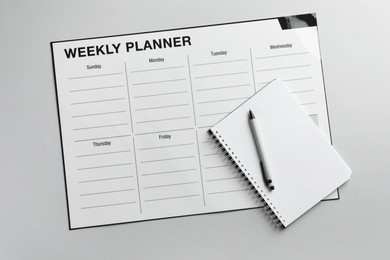 Photo of Timetable. Planner, notebook and pen on grey table, top view