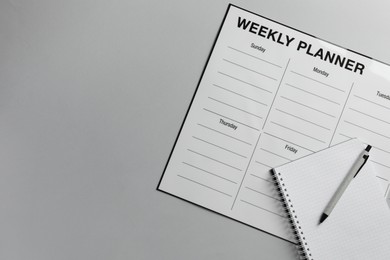 Photo of Timetable. Planner, notebook and pen on grey table, top view. Space for text