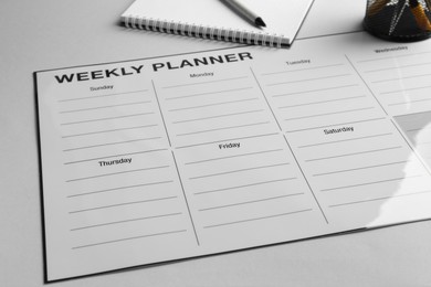 Photo of Timetable. Planner, notebook and pen on grey table, closeup