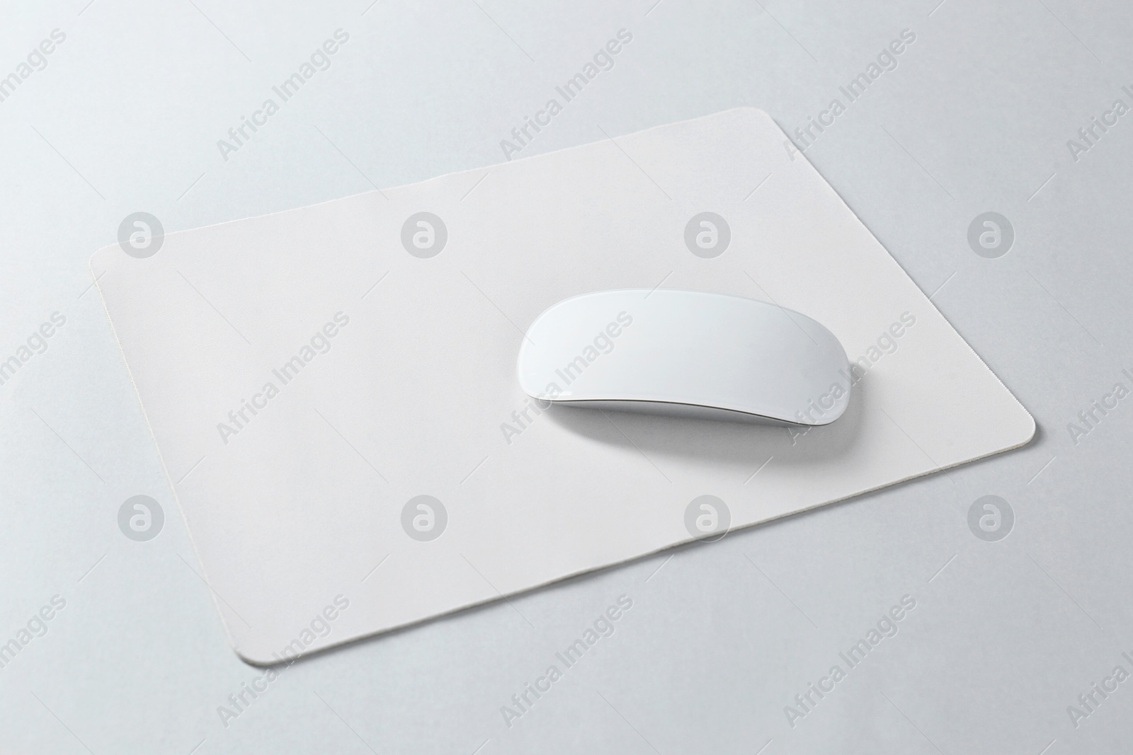 Photo of Wireless mouse and mousepad on white background