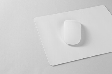 Wireless mouse and mousepad on white background, space for text