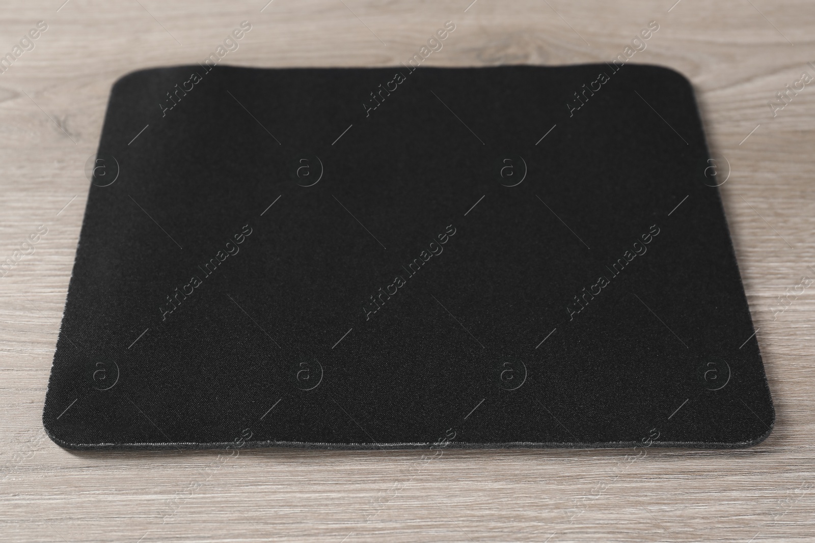 Photo of One black mouse pad on wooden table