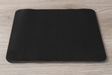 Photo of One black mouse pad on wooden table