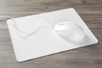 Wired mouse and mousepad on wooden table