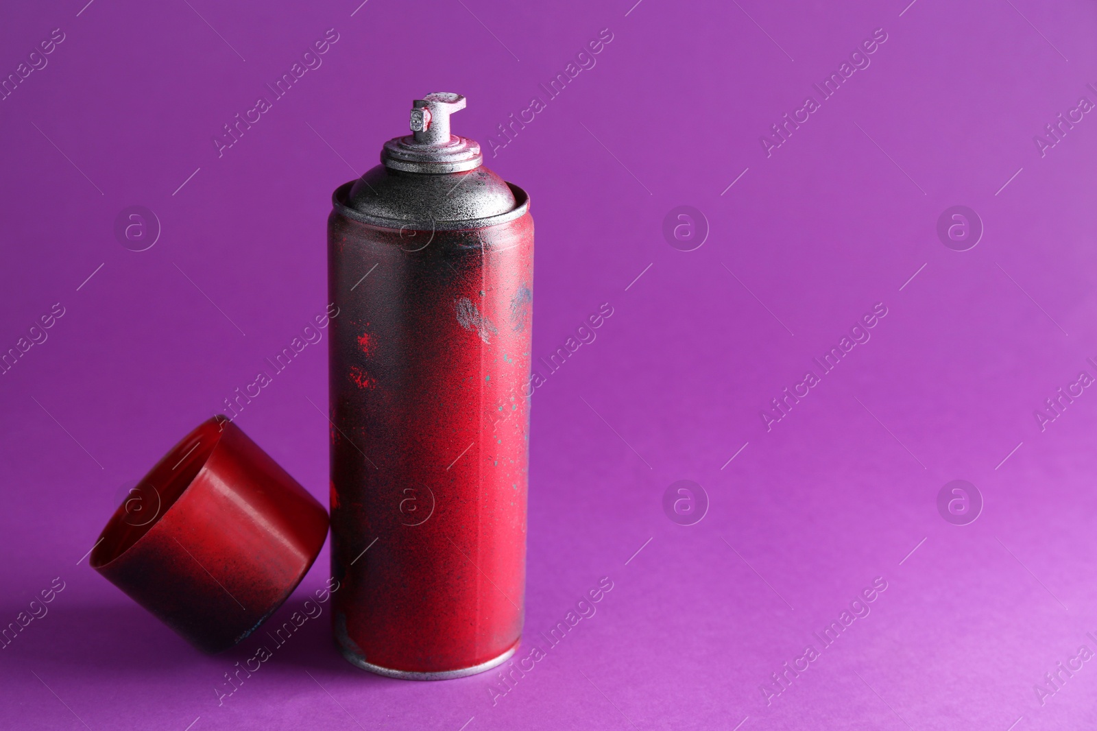 Photo of One spray paint can on violet background, space for text