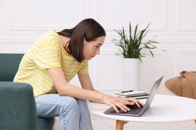 Photo of Woman with poor posture using laptop at home