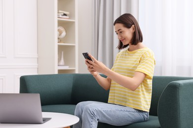 Woman with good posture using smartphone at home