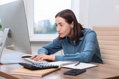 Woman with poor posture working in office