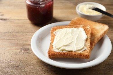 Delicious toasted bread slices with butter served on wooden table