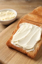 Photo of Delicious toasted bread slices with butter on table, closeup