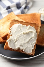 Photo of Delicious toasted bread slices with cream cheese on white wooden table, closeup