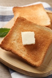 Photo of Delicious toasted bread slices with butter on table, closeup