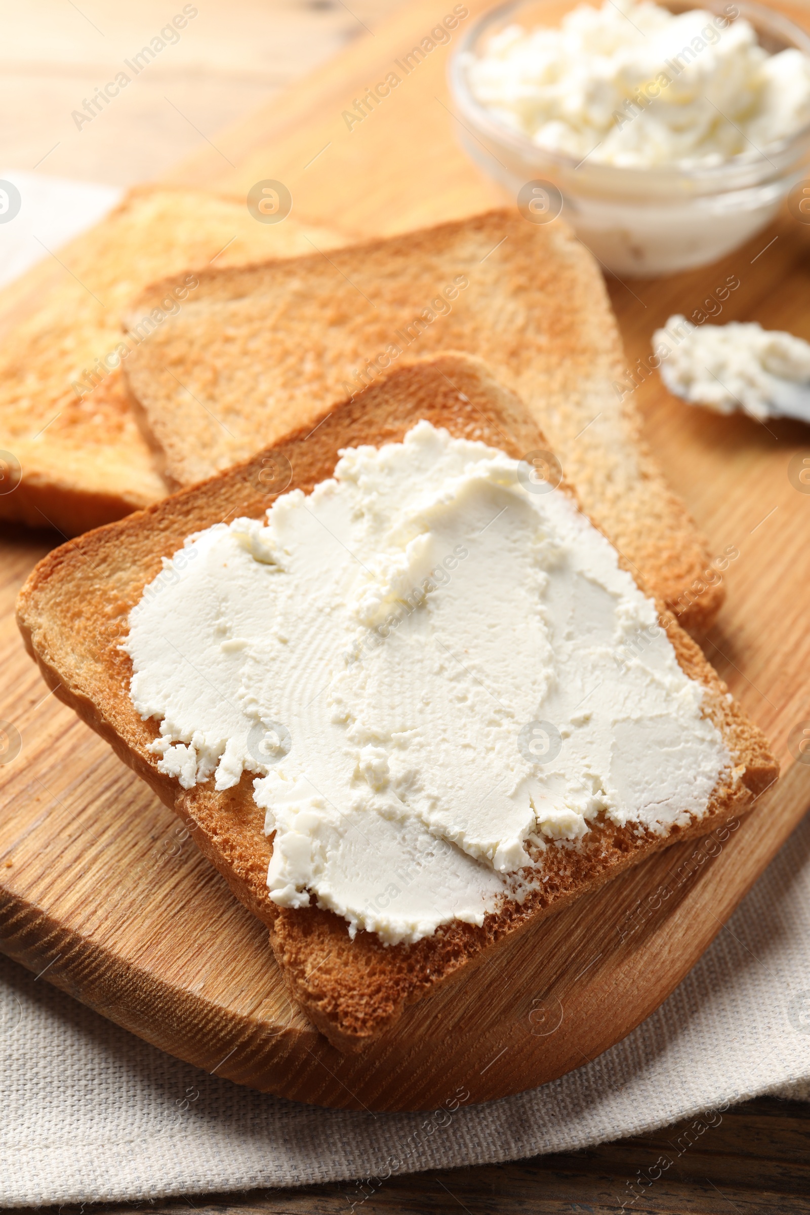 Photo of Delicious toasted bread slices with cream cheese on table