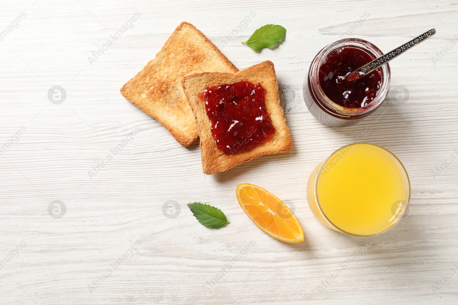 Photo of Delicious toasted bread slices served on white wooden table, flat lay. Space for text