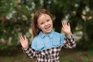 Photo of Portrait of happy little girl outdoors. Cute child