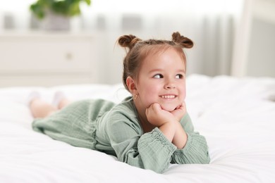 Photo of Portrait of happy little girl on bed at home