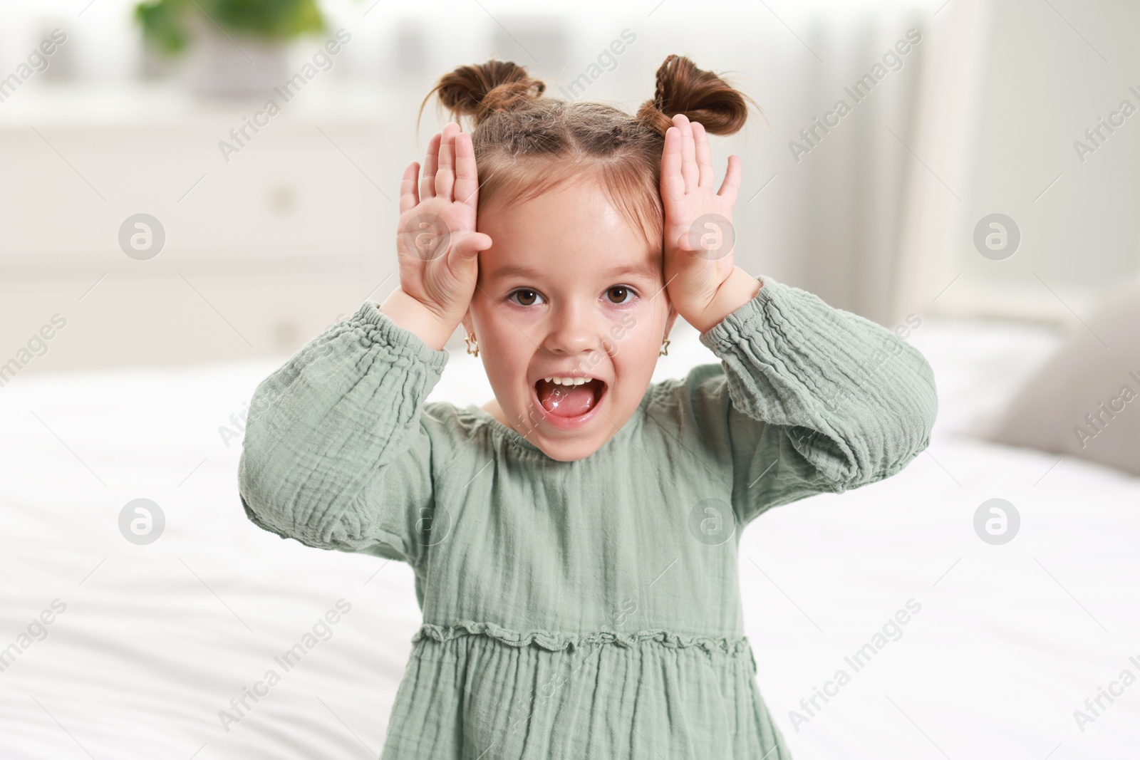 Photo of Portrait of emotional little girl in bedroom