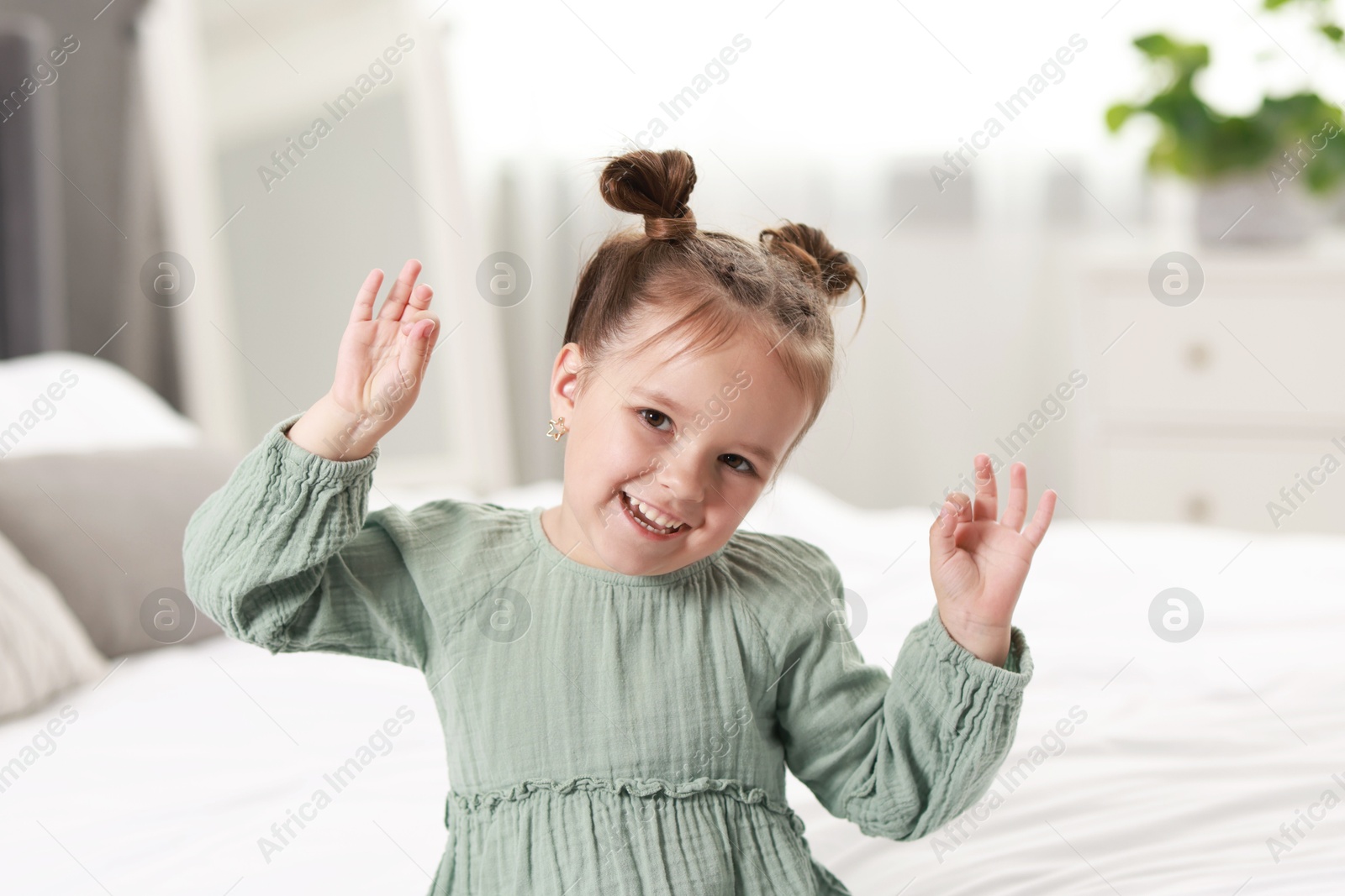 Photo of Portrait of happy little girl in bedroom