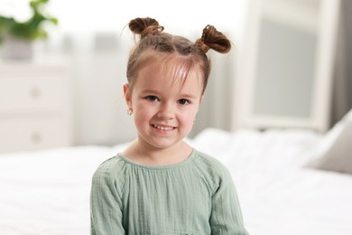 Portrait of happy little girl in bedroom