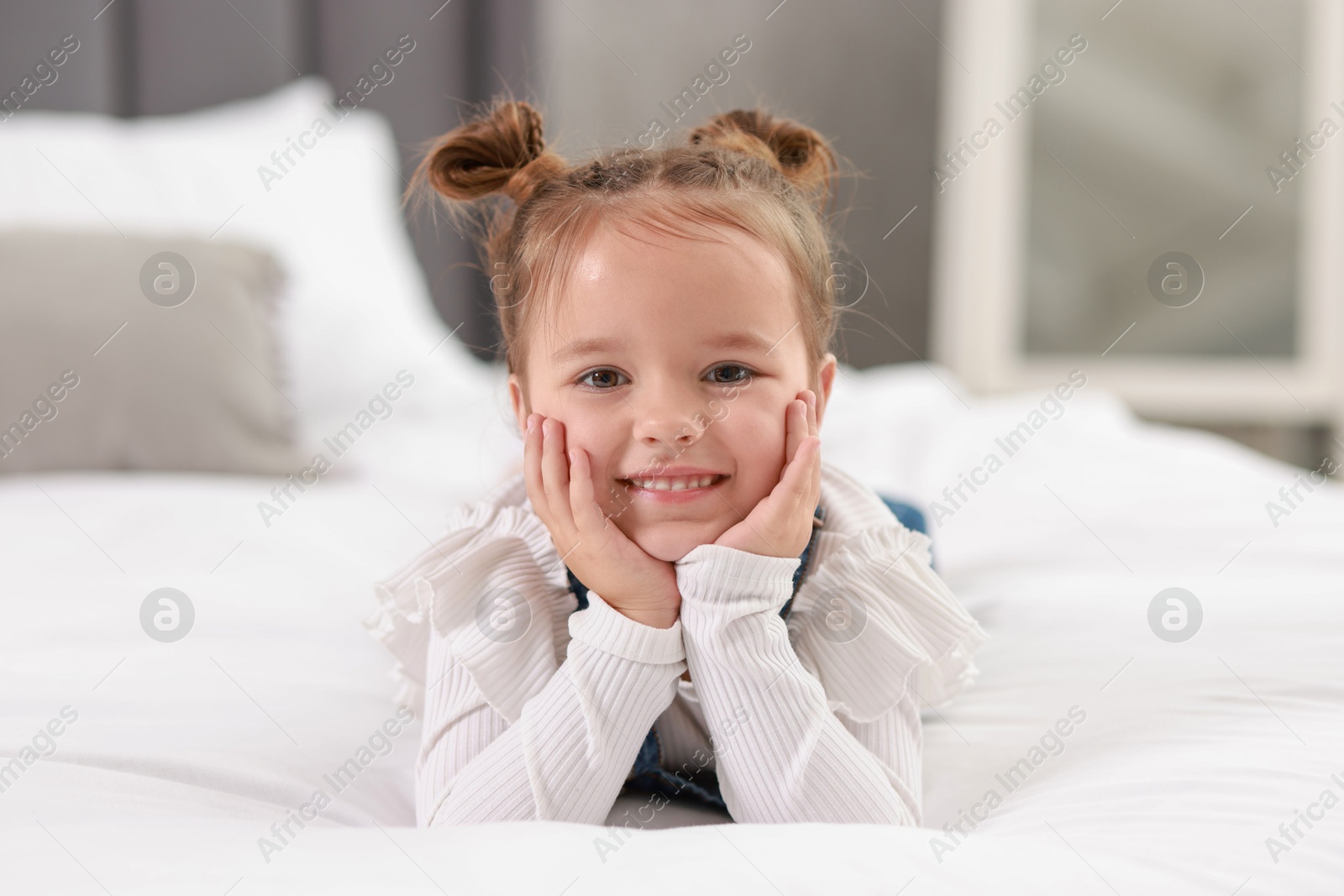 Photo of Portrait of happy little girl on bed indoors