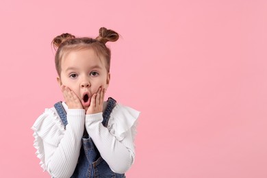 Portrait of emotional little girl on pink background, space for text