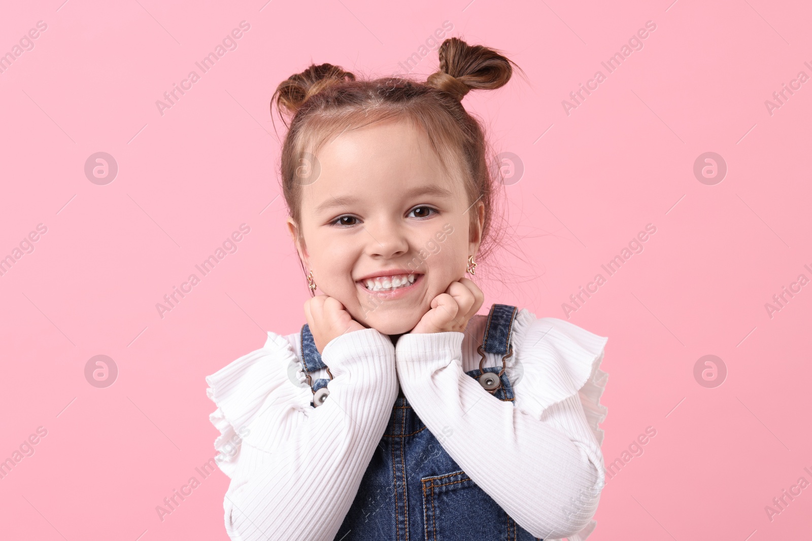 Photo of Portrait of happy little girl on pink background