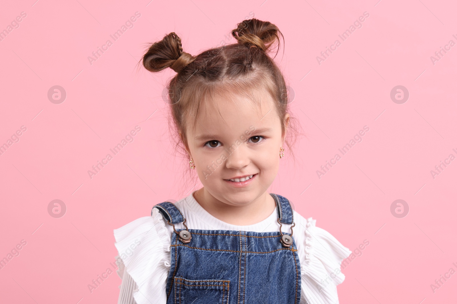 Photo of Portrait of cute little girl on pink background