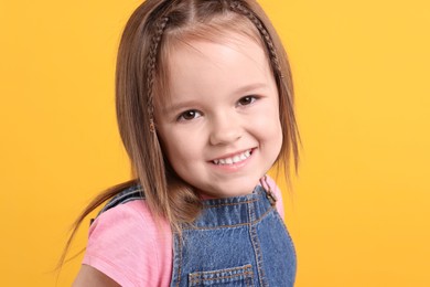 Portrait of happy little girl on orange background