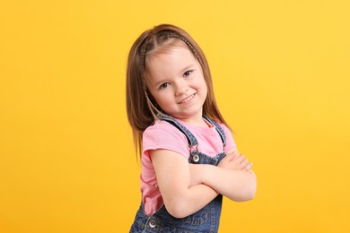 Photo of Portrait of happy little girl on orange background