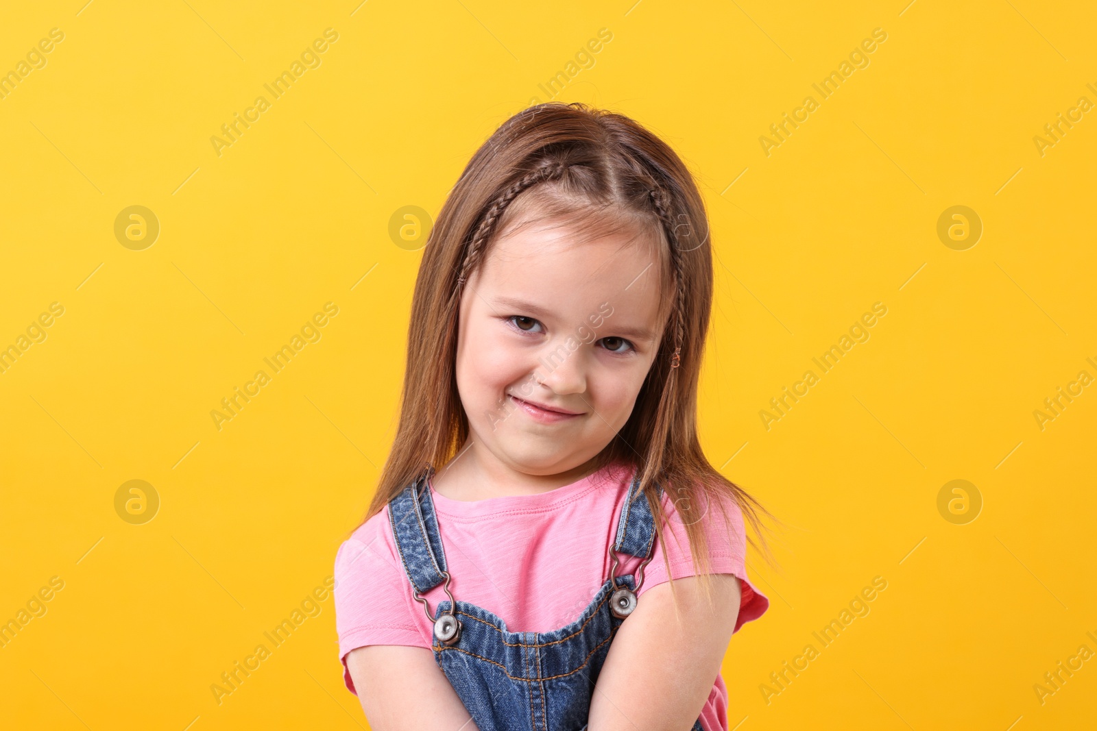 Photo of Portrait of cute little girl on orange background