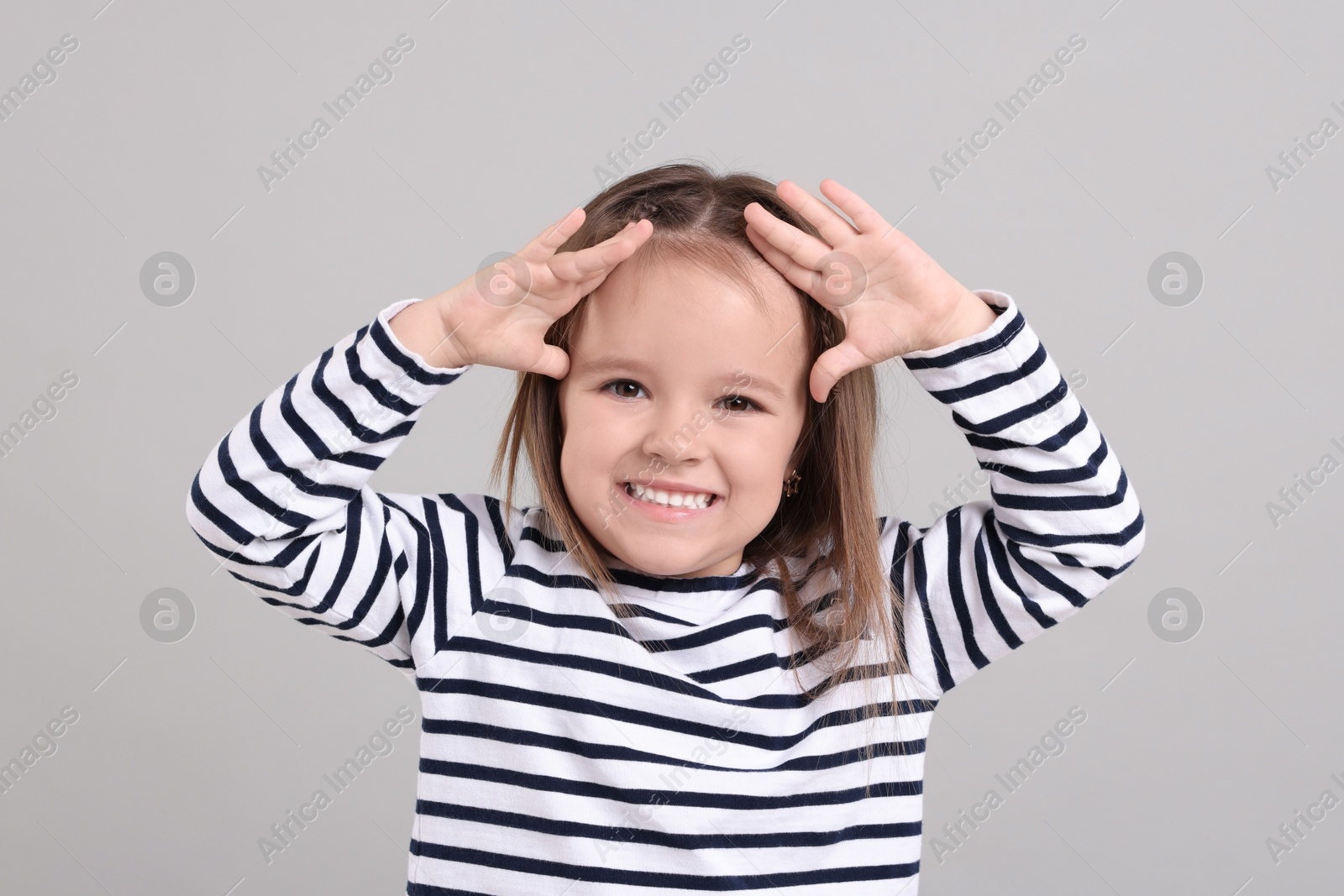 Photo of Portrait of happy little girl on grey background