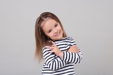 Photo of Portrait of happy little girl on grey background