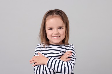 Portrait of happy little girl on grey background