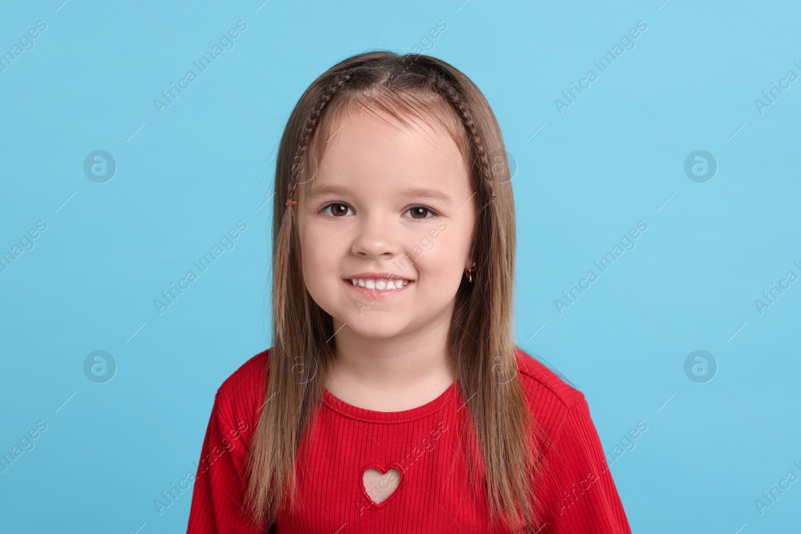 Photo of Portrait of happy little girl on light blue background