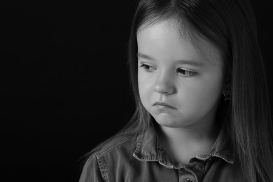 Photo of Portrait of sad girl on dark background, space for text. Black and white effect