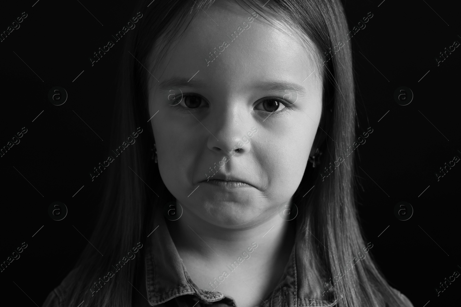 Photo of Portrait of sad girl on dark background, closeup. Black and white effect