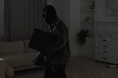 Photo of Thief stealing computer monitor at foreign house. Burglary