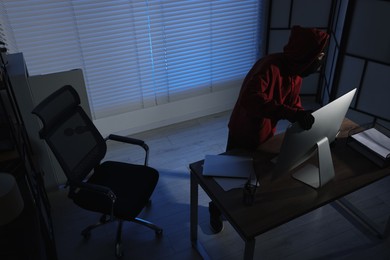 Photo of Thief stealing computer monitor in office at night, above view. Burglary